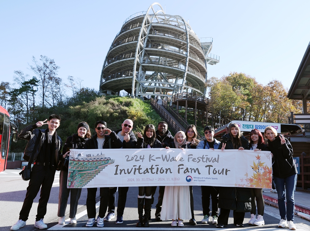 Participants in an invitational familiarization tour of this year's K-Wave Festival on Nov. 6 take a group photo in front of Mancheonha Skywalk in Danyang-gun County, Chungcheongbuk-do Province. From left are Andrei Lugtu, Ilse Gabriela Díaz Gasca, Frenky Ramiro de Jesus, Manuel Guthmann, Gahir Suchismita, Uhiene Joseph Enejo, Anastasyia Setia Widarta, Salma Knani, Aiyaphat Wankawisant, Foteini Chatzoudi, Marjorie Diaz and Yulia Veselchakova.